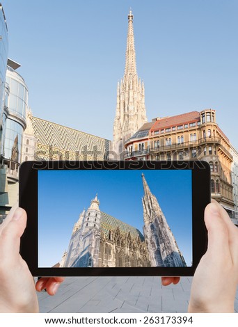 travel concept - tourist takes picture of St Stephan Cathedral, Vienna, Austria on smartphone,