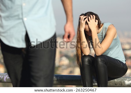 Breakup of a couple with bad guy and sad girlfriend with a city in the background Royalty-Free Stock Photo #263250467