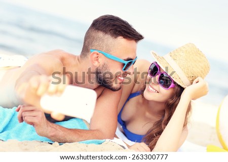 A picture of a happy couple taking selfie at the beach