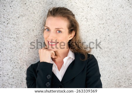 Close up portrait of an attractive business woman smiling with hand on chin