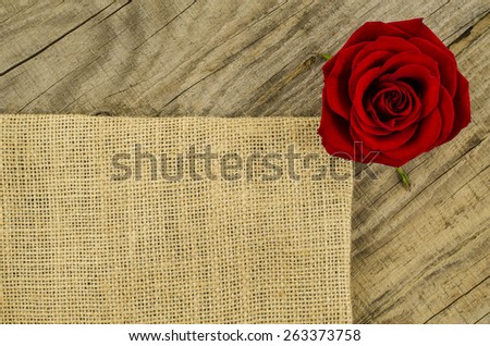 Jute, burlap texture with rose flower on old wooden table