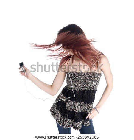 Young Woman With Tousled Hair Wearing Trendy Outfit Listening to Music from MP3, Isolated on White Background.