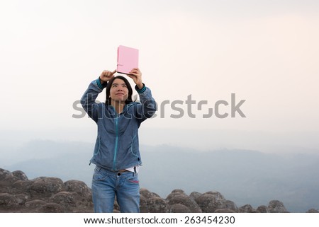 young woman selfie during Sunset on mountain with landscape view