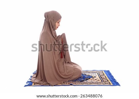 Young beautiful muslimah pray on white background                                