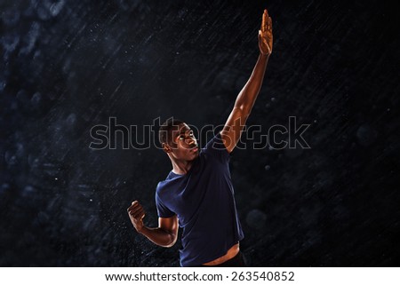 Serious young man with hand gestures against black background
