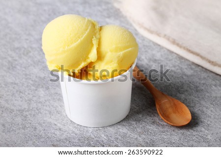 passion fruit sorbet in white cup with a wooden spoon