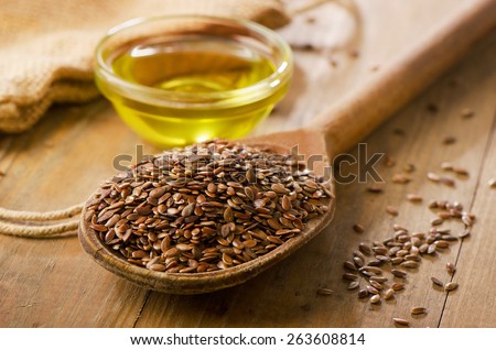 Brown flax seeds on a spoon and flaxseed oil. Royalty-Free Stock Photo #263608814