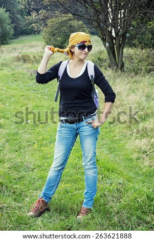 Young positive female tourist hiking in outdoors. Beauty and fashion.