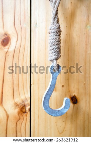 Vintage hook hanging on wooden panel wall, decoration