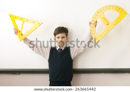The boy with angle and protractor at electronic board in school