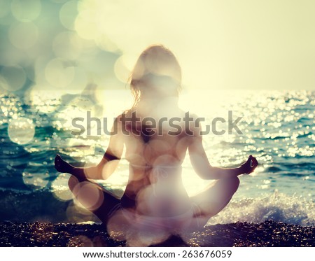Woman Practicing Yoga by the Sea. Rear View. Double Exposure Filtered Photo with Bokeh. Soul Concept. Royalty-Free Stock Photo #263676059