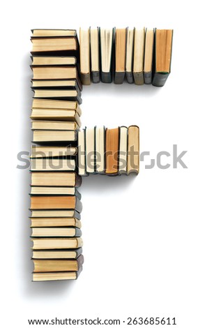 Letter F formed from the page ends of closed vintage hardcover books standing on a white background from a set or series of numbers