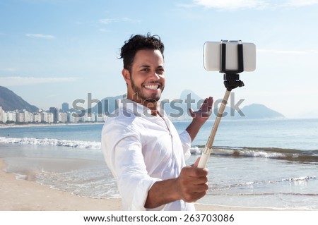 Brazilian man making selfie with a stick at Copacabana beach Royalty-Free Stock Photo #263703086