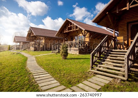 Traditional wooden cottages at sunny day in the countryside Royalty-Free Stock Photo #263740997