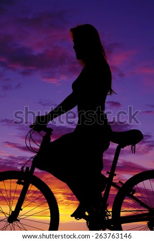 a silhouette of a woman on her bike, riding for the pleasure of it.