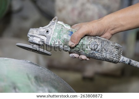 worker polishing and cutting Fiberglass with angle grinder, power tool used for cutting, grinding and polishing