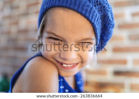 Beautiful happy little girl in blue beret smile.