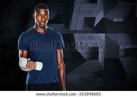 Portrait of a casual man lifting dumbbells against dark room