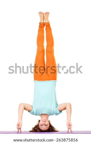 Young woman balancing on her arms while doing yoga. 