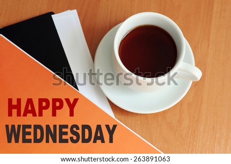 Happy Wednesday message written on a paper folder. Close-up of a coffee cup on the table