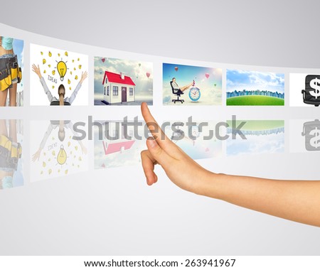 Business lady and buildings. Finger presses one of virtual screens. Mirror reflection