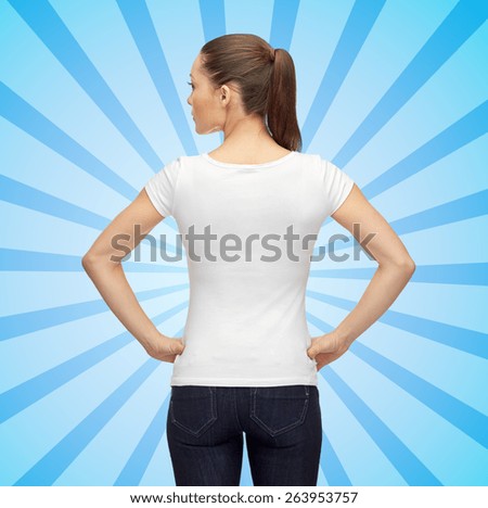 t-shirt design, advertisement and people concept - woman in blank white t-shirt over blue burst rays background from back