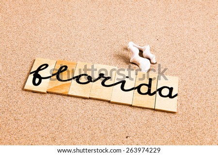 Words formed from small pieces of wood containing a sun and beach tourist destination, florida