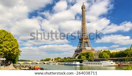 Eiffel tower over Seine River, Paris, France. Majestic Eiffel tower is famous landmark of Europe. Scenic view of Tour Eiffel on sky background. Panorama of Paris city, boats in summer. Travel theme.
