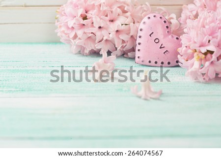 Background with fresh flowers hyacinths  and decorative heart on turquoise painted wooden planks. Selective focus. Place for text. Toned image.