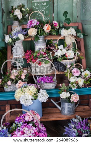 shelves with basket of flowers in a flower shop, peonies, roses, artificial flowers