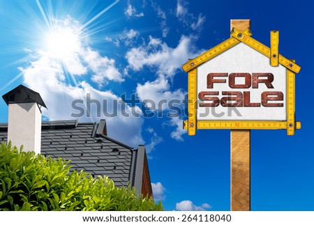 House For Sale Sign - Wooden Meter. Yellow wooden meter ruler in the shape of house with text for sale. For sale real estate sign on blue sky with roof, clouds and sun rays