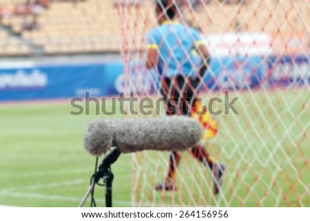 blurry Professional sport microphone on a football field with referee in the background