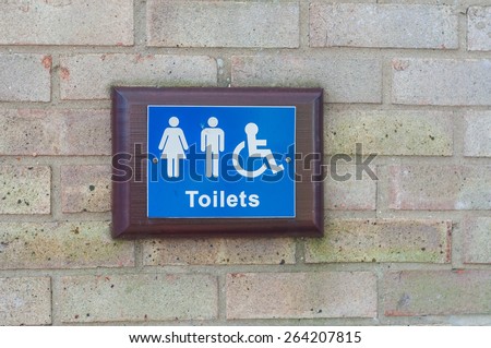 Toilets sign for public restroom mounted on a brick wall