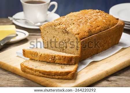 Banana Bread with Slices Cut Off the End on a Cutting Board Royalty-Free Stock Photo #264220292