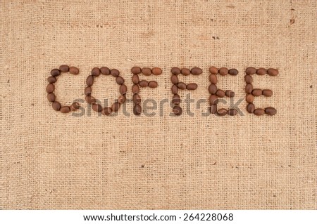 The word coffee made from coffee beans on burlap background