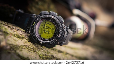 Sport watch on hand with empty screen on nature green background