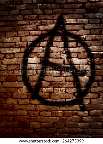 Anarchy symbol spray painted on a brick wall                               