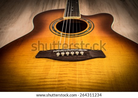 Acoustic Guitar on top of a wooden table