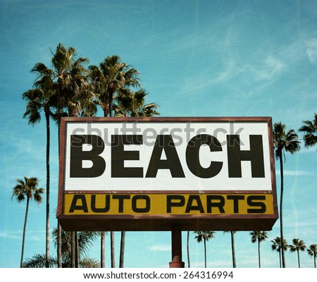 aged and worn vintage photo of auto parts sign with palm trees