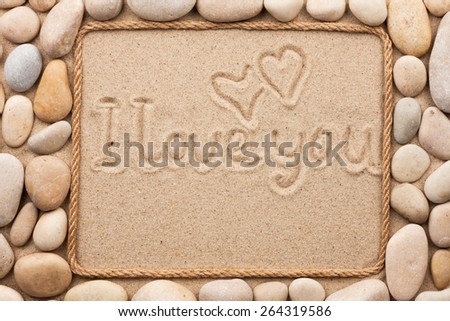 Beautiful frame made of rope and  sea shells on the sand with text i love you, as background