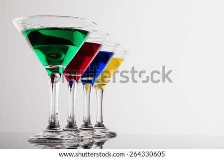 color cocktails in martini glasses organized in a line