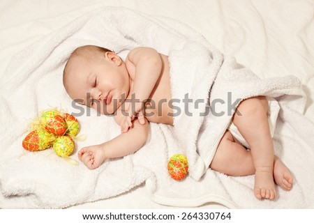 Sleeping baby with Easter eggs
