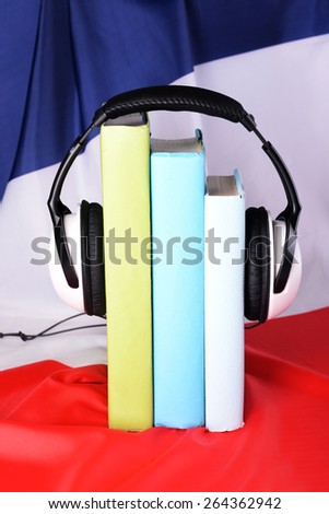 Books and headphones on French flag background