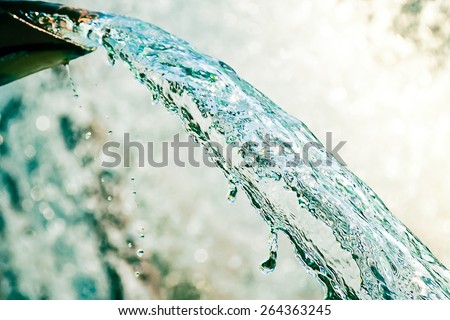 Close up of water gushing out of the pipe Royalty-Free Stock Photo #264363245