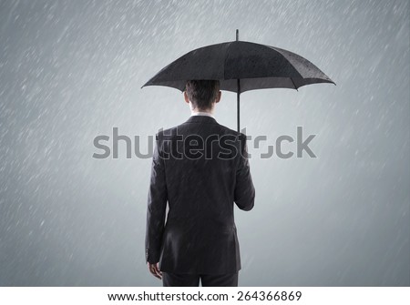 Businessman standing with an umbrella