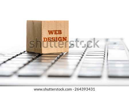 Web design, computing and e-business concept with a wooden block standing on top of a white computer keyboard with the words Web Design isolated on white with copyspace, receding perspective.