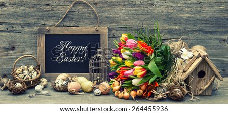Easter decoration with eggs and tulip flowers. Vintage background with sample text Happy Easter! Retro style toned picture.