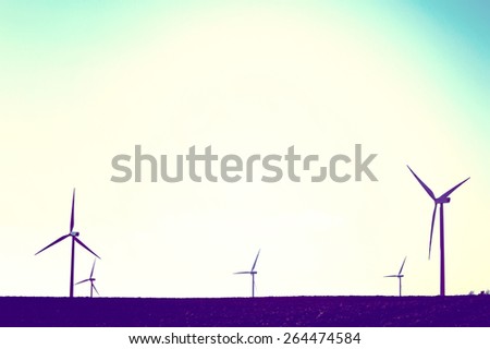 Windmills on the field. Vintage instagram picture. Alternative energy.