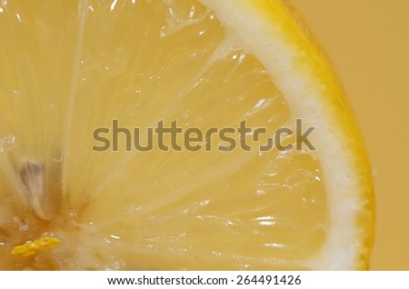 close-up of a slice of lemon, yellow background