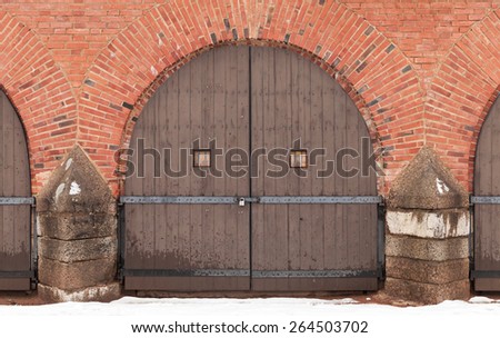 Old locked wooden gate in red brick fortress wall, Hamina, Finland Royalty-Free Stock Photo #264503702